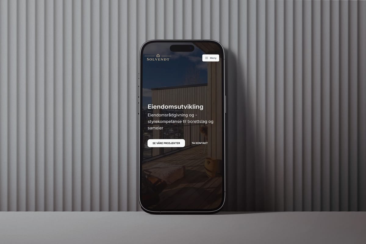 En iPhone som viser Solvendt sin nettside på mørk bakgrunn med vertikale striper. Skjermen viser overskriften 'Eiendomsutvikling' med undertekst om eiendomsrådgivning og styrekompetanse, samt to knapper for 'SE VÅRE PROSJEKTER' og 'TA KONTAKT'.